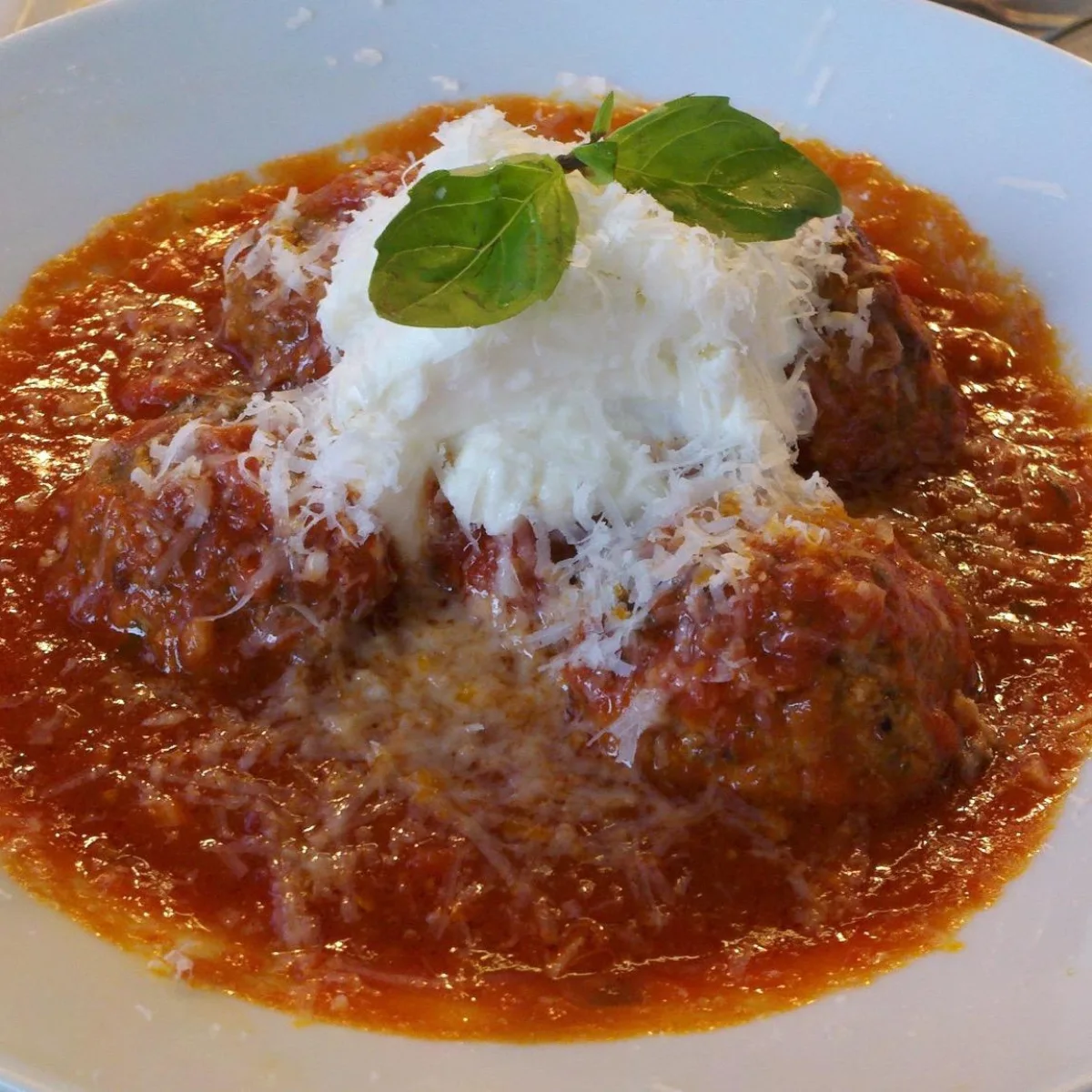 Meatballs with tomato sauce, cheese and basil